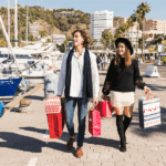 Pareja con bolsas de compra visitando Puerto Banús